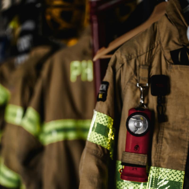 Fire fighter gear hanging in a rack.